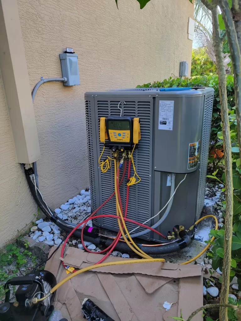 Elsmar Air technician inspecting an AC condensate drain line in Coral Springs