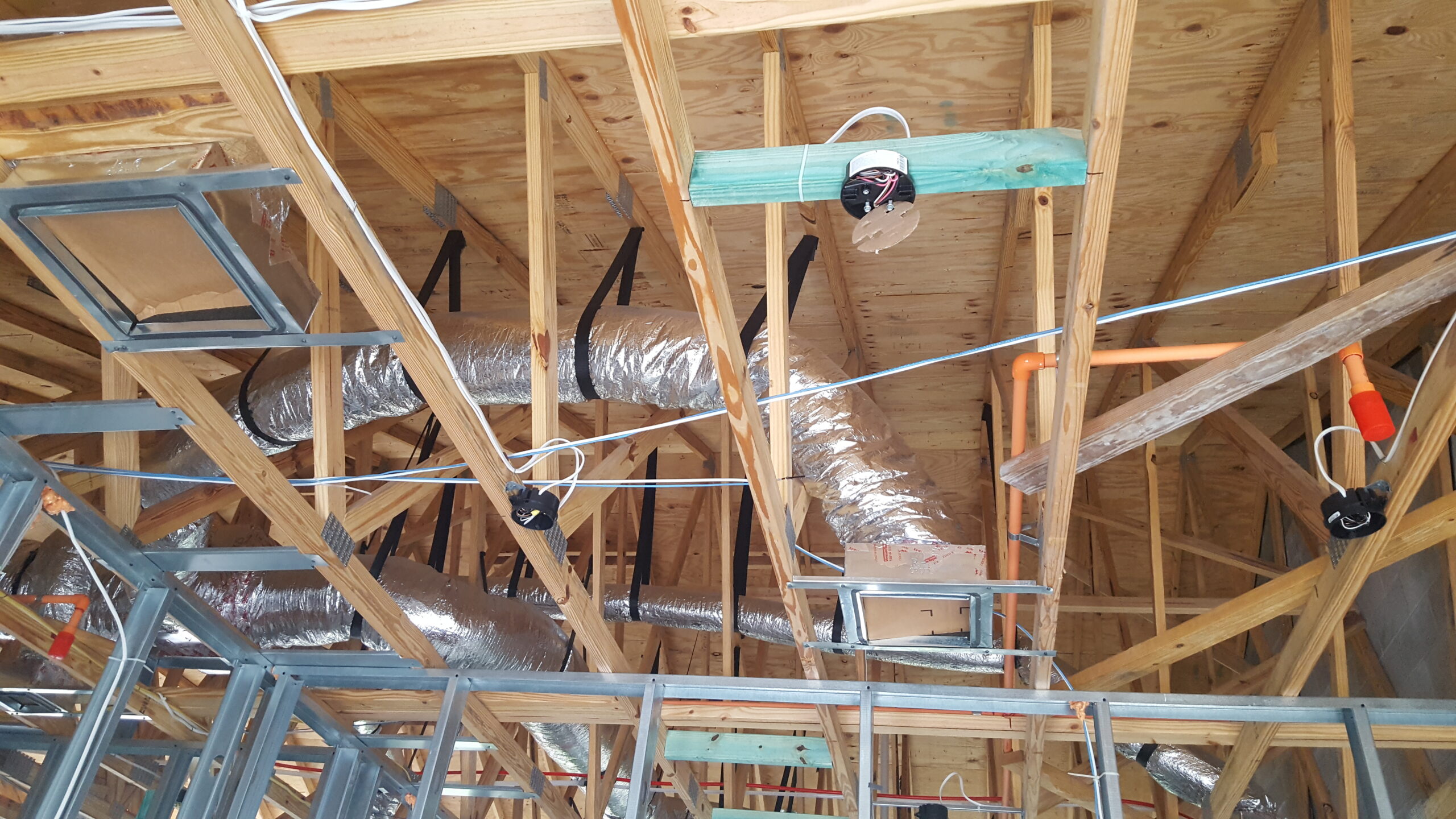 Insulated air ducts installed in an attic during construction